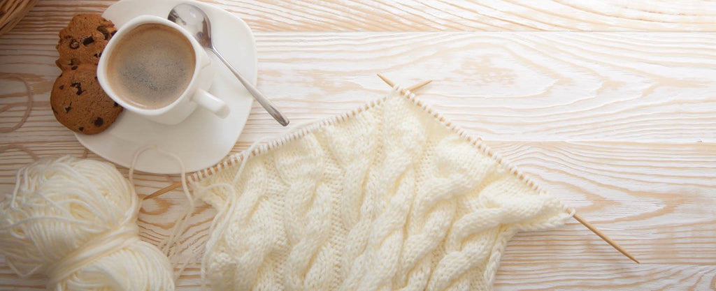 cream colored yarn and knitting needles