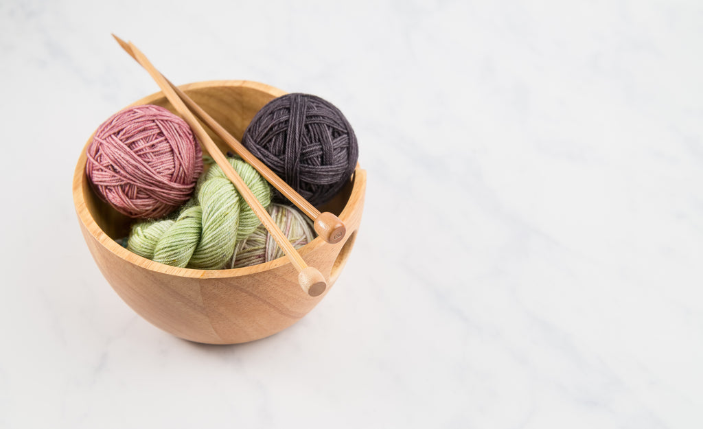 Bowl of yarn with knitting needles